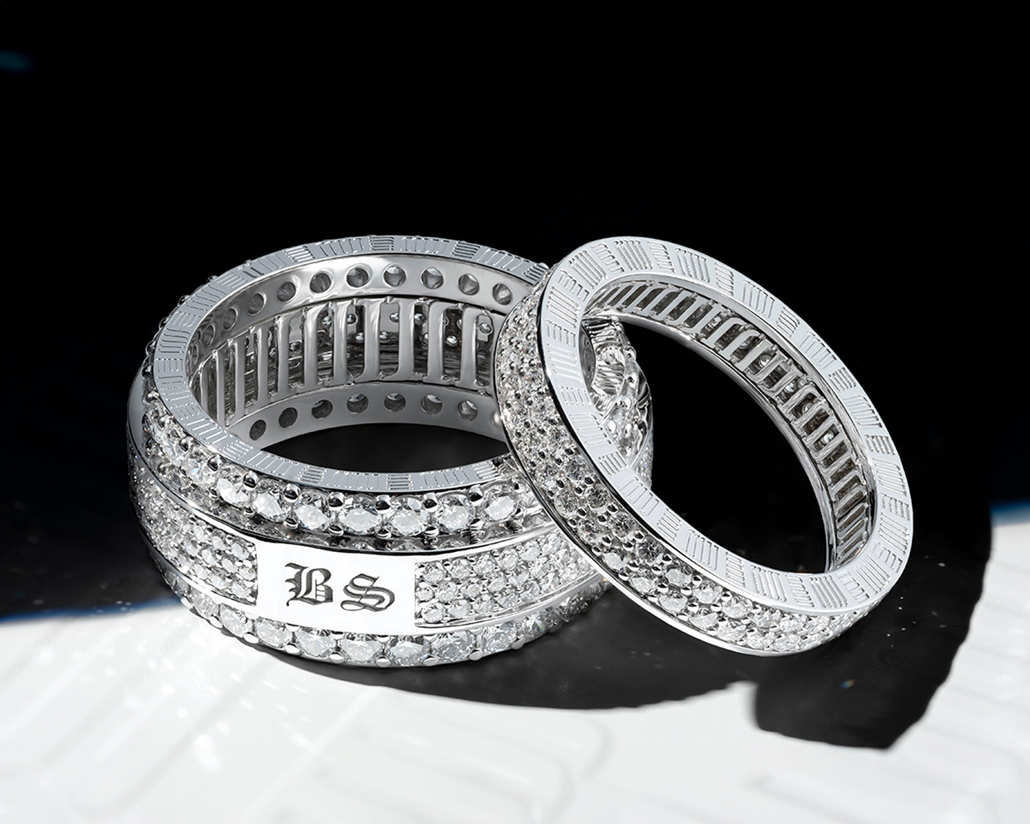 Customised diamond rings by MJ Jones with engraved initials, showcasing luxury craftsmanship and personalisation. These white gold rings feature pave-set diamonds, offering elegance and exclusivity for those seeking bespoke fine jewellery. Ideal for high-end jewellery lovers looking for unique, personalised pieces.